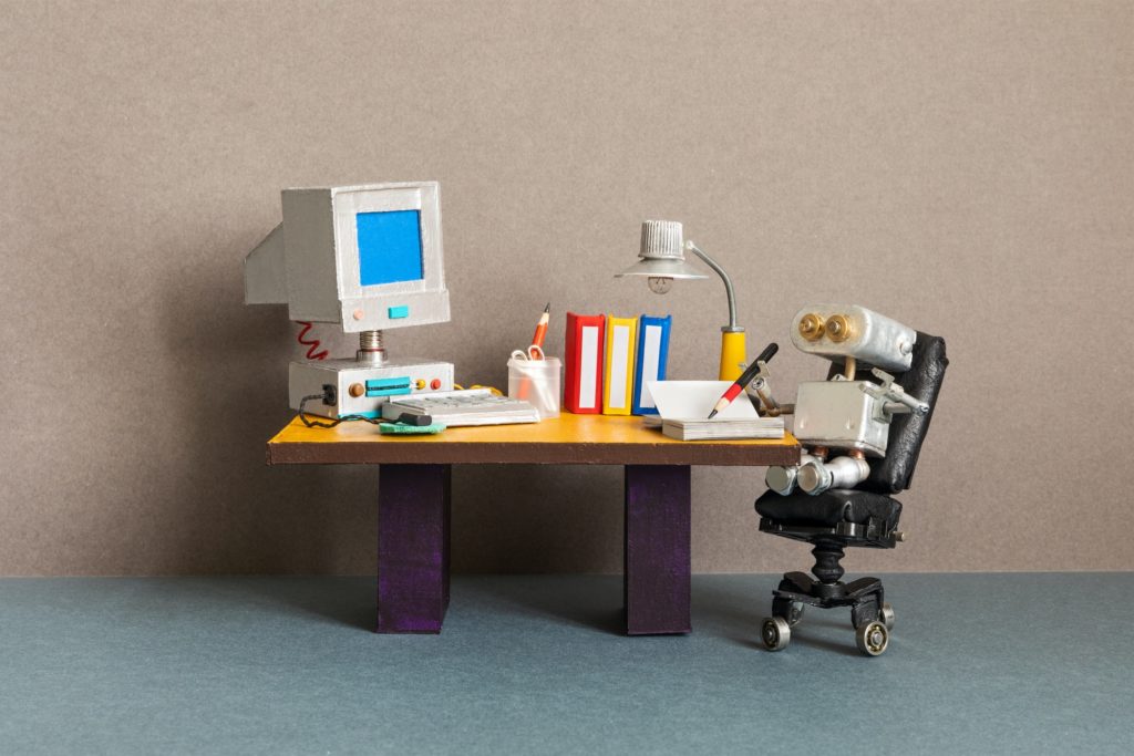 Robot office manager, retro style workplace. Old table with vintage computer, desk lamp and books.